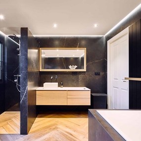 Modernes Badezimmer mit schwarzer Marmorwand, Holzwaschtisch und großer Dusche.